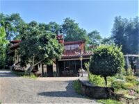 A building with driveway and trees