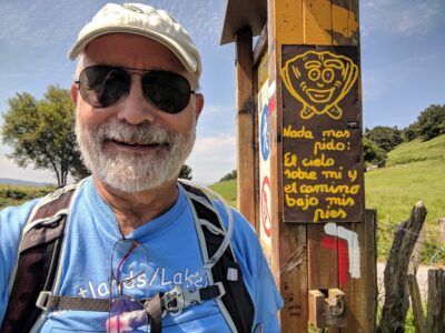 An old man next to a signpost