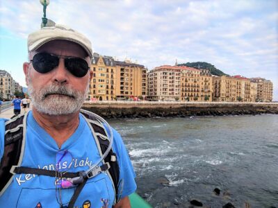 Man standing on a bridge next to a rushing river