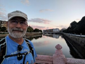 An old man on a bridge over a river