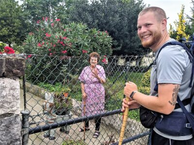 A young peregrino and older woman chatting across a fence