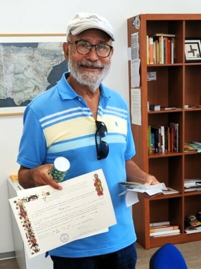 A senior pilgrim receives his Compostela after completing el Camino de Santiago del Norte